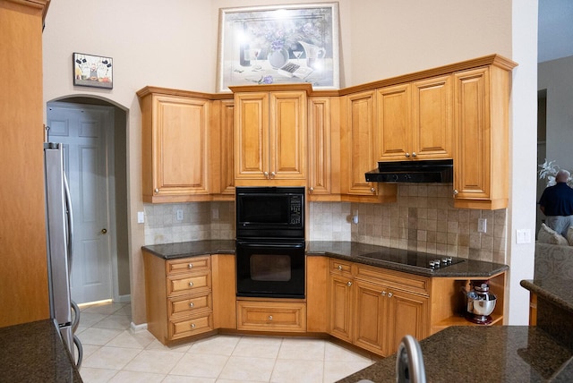 kitchen featuring black appliances, decorative backsplash, dark stone countertops, and light tile patterned floors