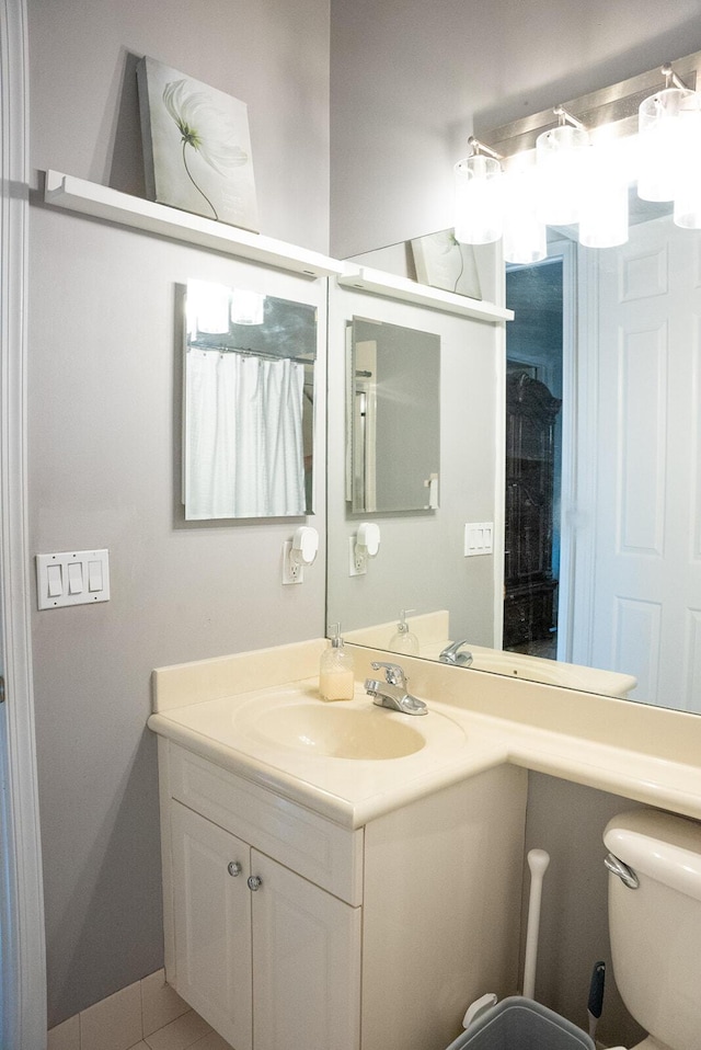 bathroom with tile patterned flooring, vanity, and toilet