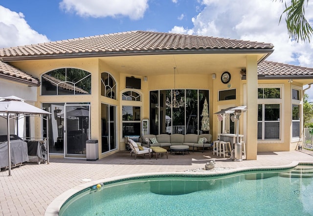 rear view of property featuring outdoor lounge area and a patio