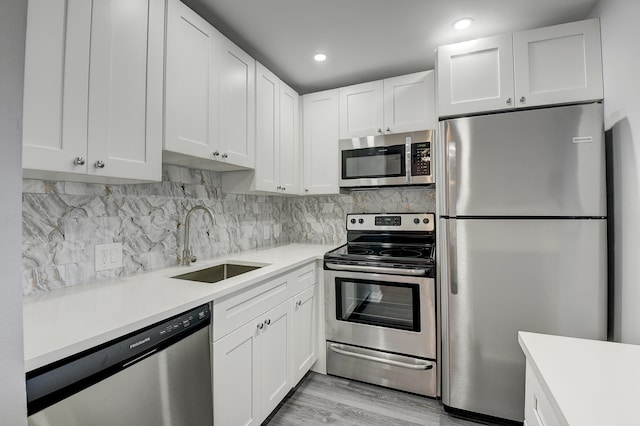 kitchen featuring stainless steel appliances, white cabinetry, and sink