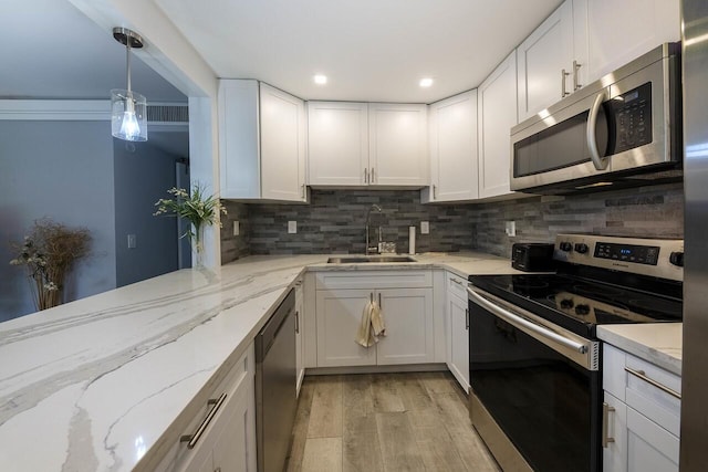 kitchen featuring sink, light hardwood / wood-style flooring, light stone countertops, white cabinetry, and stainless steel appliances