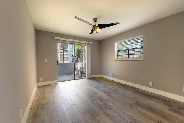 empty room with ceiling fan, a healthy amount of sunlight, and light wood-type flooring