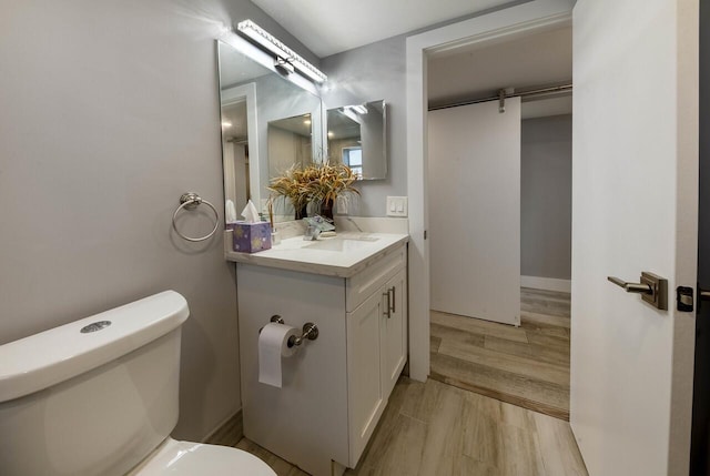 bathroom featuring hardwood / wood-style floors, vanity, and toilet