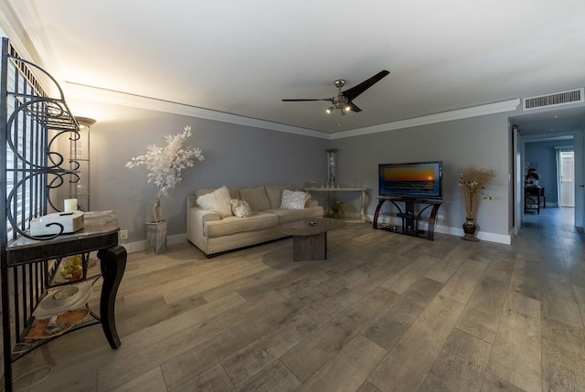 living room with hardwood / wood-style floors, ceiling fan, and crown molding