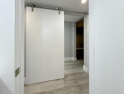 corridor with a barn door and light wood-type flooring