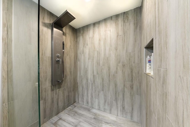 bathroom featuring a tile shower and tile walls