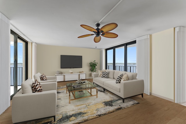 living room featuring a ceiling fan, a wealth of natural light, floor to ceiling windows, and wood finished floors