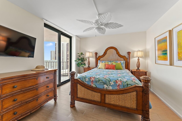 bedroom with access to exterior, floor to ceiling windows, baseboards, and wood finished floors