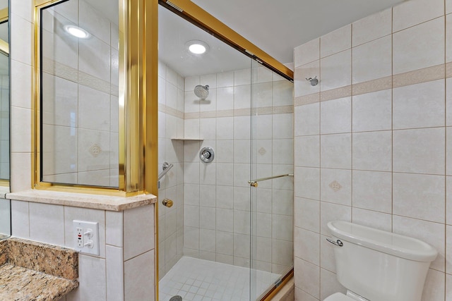 full bath with toilet, a shower stall, and tile walls