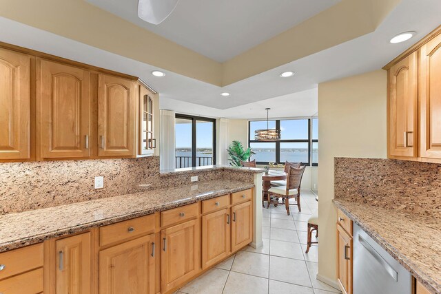 dining area with a water view and light tile patterned floors