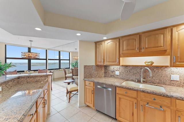 kitchen with dishwasher, light stone counters, a water view, and a sink