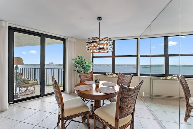 dining area with a water view, light tile patterned floors, expansive windows, and a notable chandelier