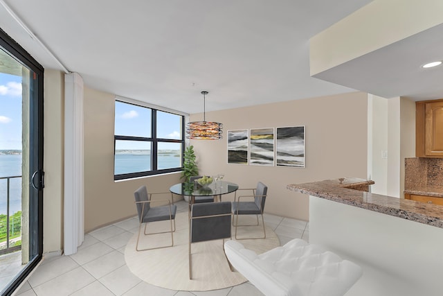 dining room featuring a water view and light tile patterned floors