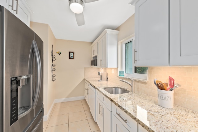 kitchen featuring sink, white cabinetry, light stone countertops, white dishwasher, and stainless steel fridge