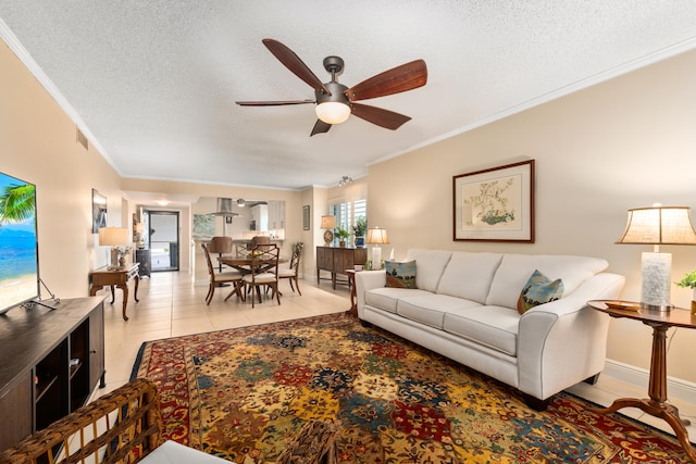 living room featuring ornamental molding, ceiling fan, light tile patterned floors, and a textured ceiling