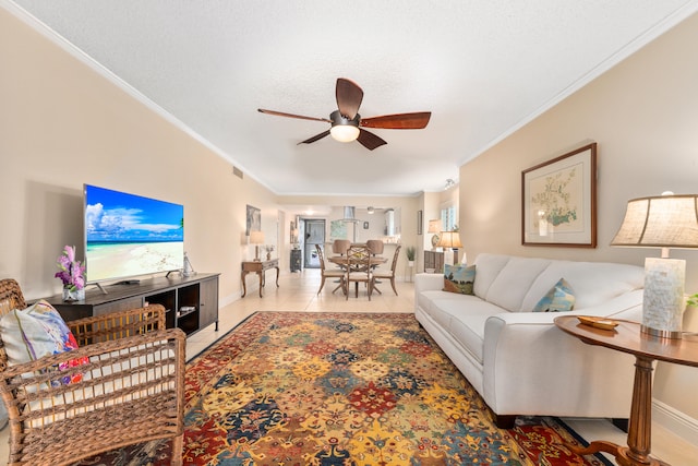 living room featuring a textured ceiling, crown molding, light tile patterned floors, and ceiling fan