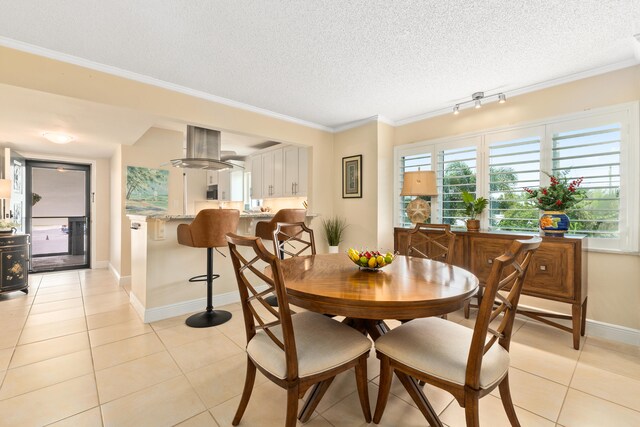 tiled dining space with ornamental molding and a textured ceiling