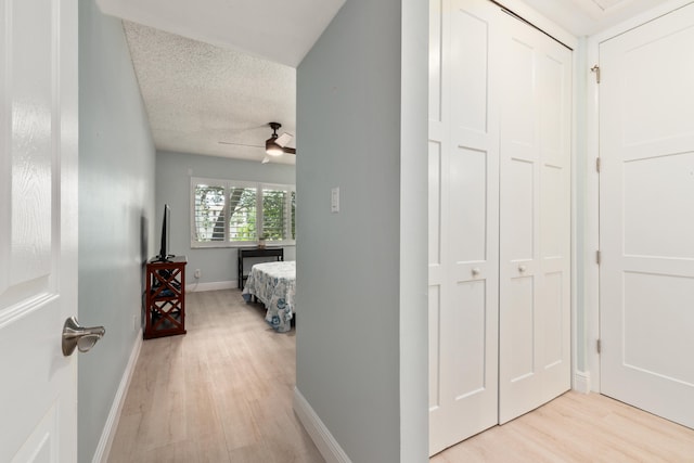 hallway featuring a textured ceiling and light hardwood / wood-style floors