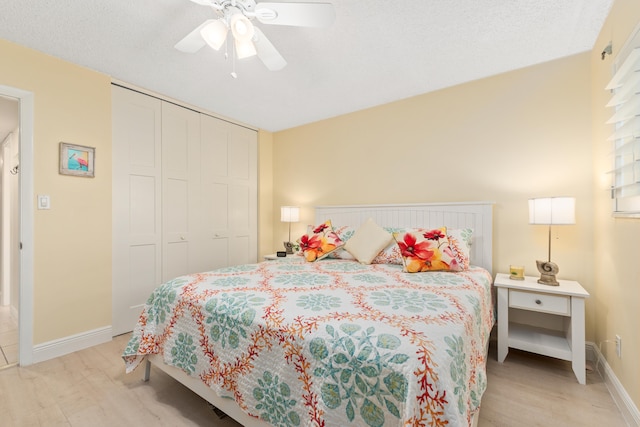 bedroom with light hardwood / wood-style flooring, a closet, ceiling fan, and a textured ceiling