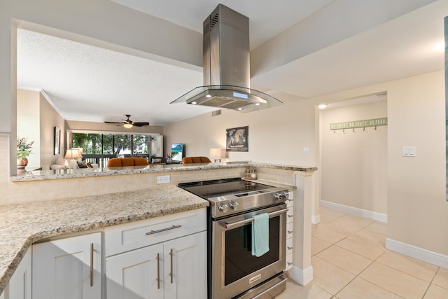 kitchen featuring light stone counters, white cabinets, ceiling fan, high end stainless steel range, and island exhaust hood