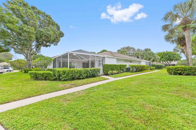 exterior space with a front lawn and glass enclosure