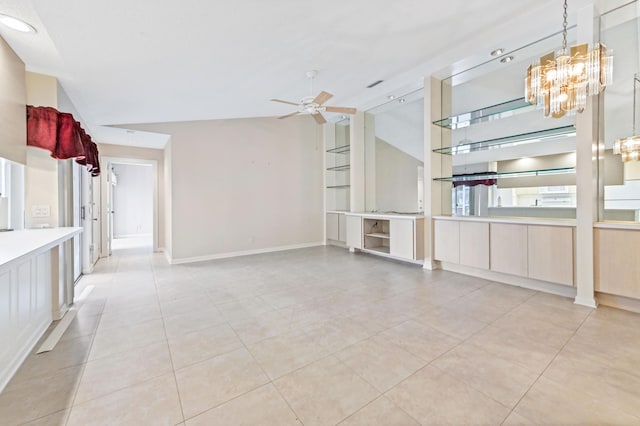 unfurnished living room with lofted ceiling, ceiling fan with notable chandelier, and light tile patterned floors