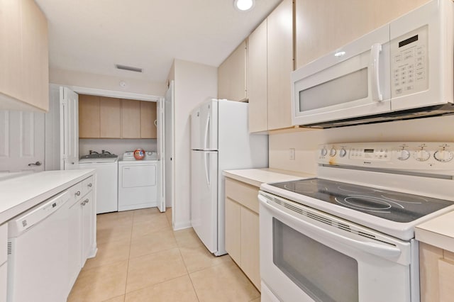 kitchen featuring white appliances, washer and dryer, and light tile patterned floors