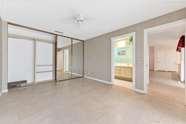 unfurnished bedroom with light tile patterned floors, a closet, and ceiling fan