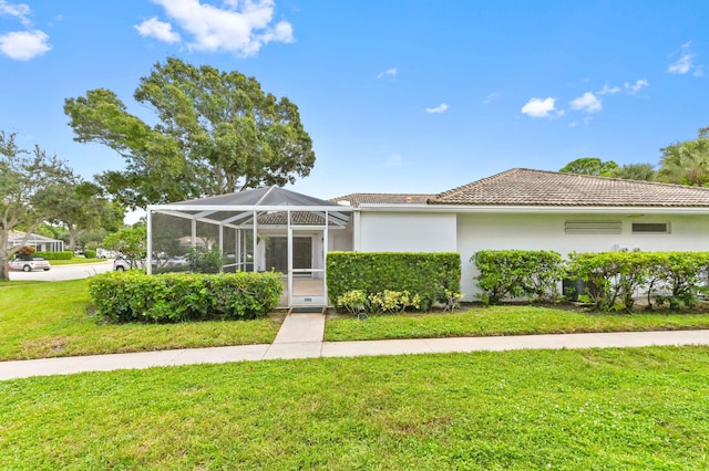 view of front of property featuring a front yard and glass enclosure