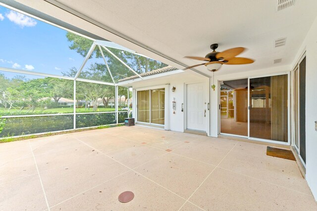 unfurnished sunroom with ceiling fan