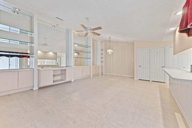 unfurnished living room featuring ceiling fan with notable chandelier and light tile patterned floors