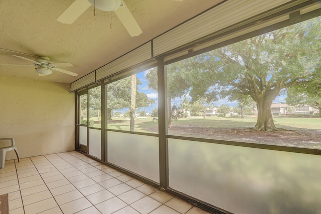 unfurnished sunroom featuring ceiling fan and plenty of natural light