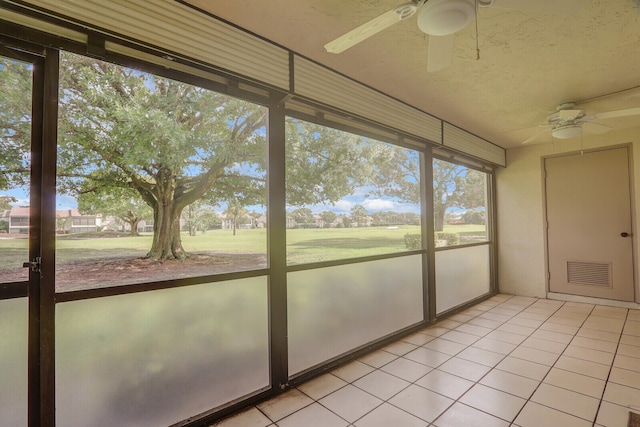 unfurnished sunroom with ceiling fan and a wealth of natural light