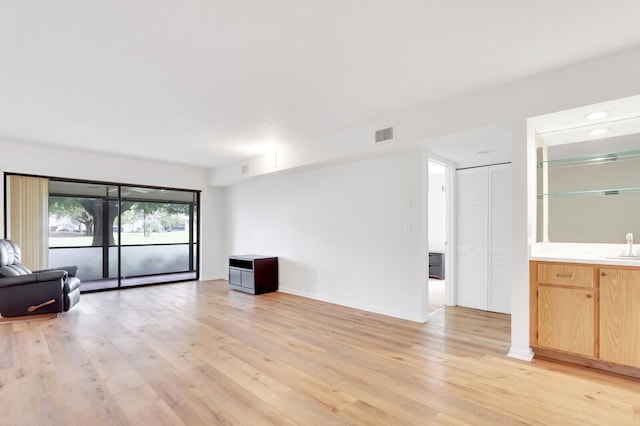 unfurnished living room featuring light hardwood / wood-style floors and sink