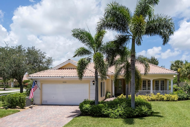 mediterranean / spanish-style home featuring cooling unit, a garage, and a front yard