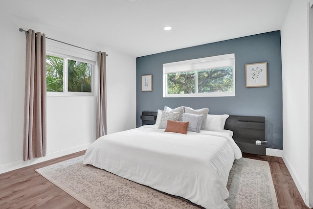 bedroom featuring hardwood / wood-style floors and multiple windows