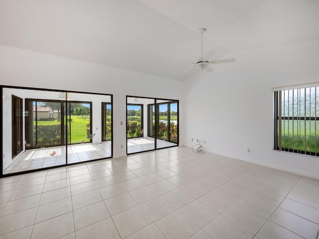 tiled empty room with vaulted ceiling and ceiling fan