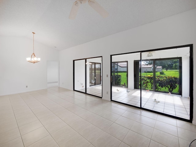 tiled spare room with ceiling fan with notable chandelier, high vaulted ceiling, and a healthy amount of sunlight