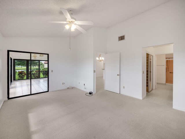 empty room with a textured ceiling, ceiling fan with notable chandelier, light carpet, and high vaulted ceiling