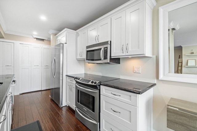 kitchen featuring ornamental molding, stainless steel appliances, dark wood-type flooring, and white cabinetry