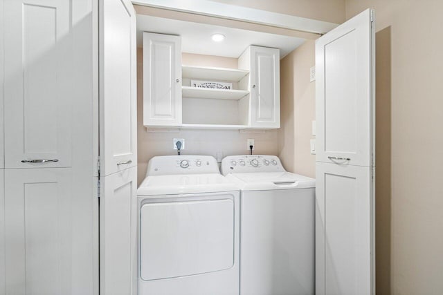 laundry area featuring separate washer and dryer and cabinets