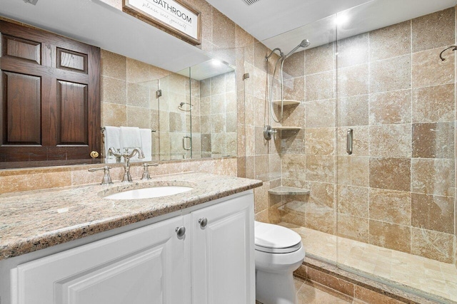 bathroom featuring walk in shower, tile walls, vanity, and toilet