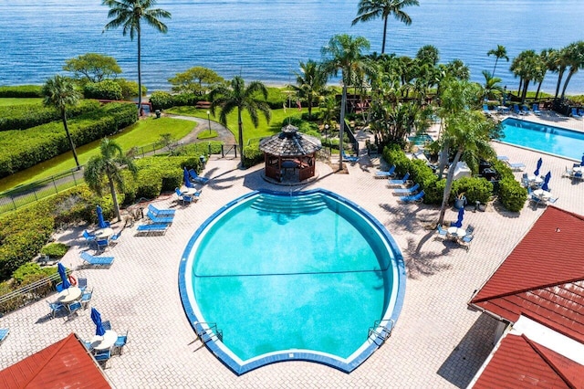 view of swimming pool with a patio, a gazebo, a water view, and a fire pit