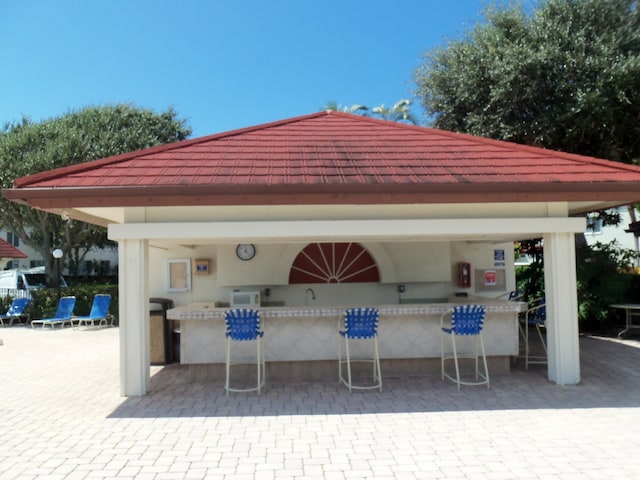 view of patio / terrace featuring an outdoor wet bar and a gazebo