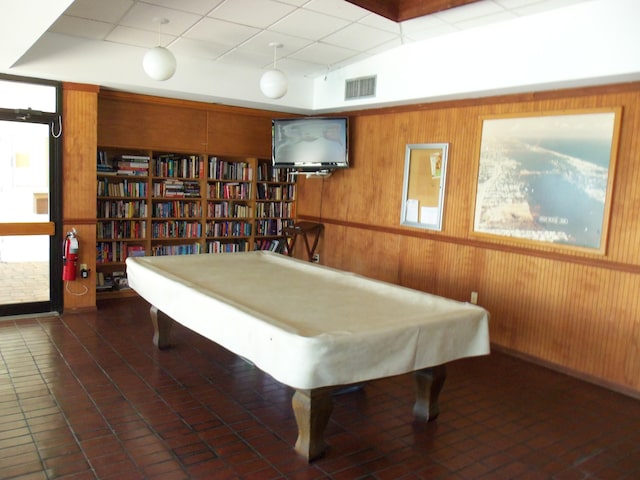 game room featuring dark tile patterned floors, pool table, wood walls, and a paneled ceiling