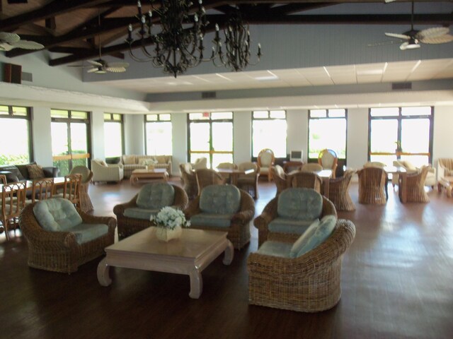 living room with ceiling fan, plenty of natural light, hardwood / wood-style floors, and high vaulted ceiling