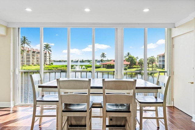 dining room featuring ornamental molding, a water view, and plenty of natural light