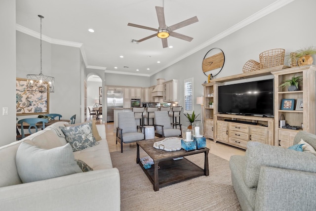 living room with ceiling fan with notable chandelier and crown molding