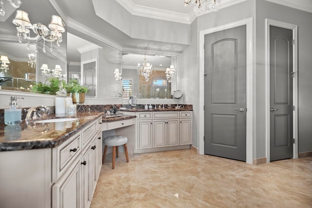 bathroom with ornamental molding, a notable chandelier, and vanity