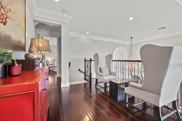 living area with ornamental molding, dark hardwood / wood-style flooring, and a chandelier